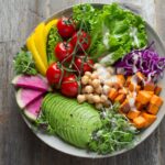 Colorful assortment of fresh healthy weight loss foods including vegetables salmon and eggs